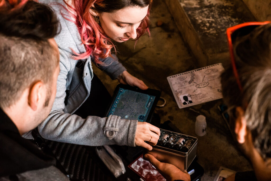 Equipa à volta do kit do escape game, com o iPad e os materiais da missão