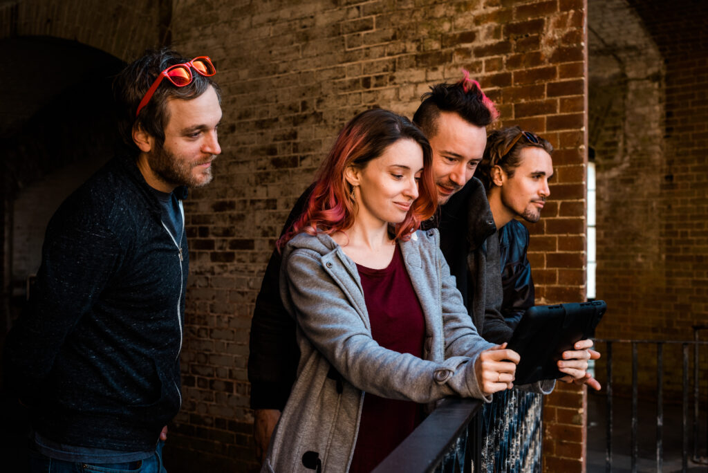 Grupo de jogadores a consultar o iPad durante um escape game ao ar livre