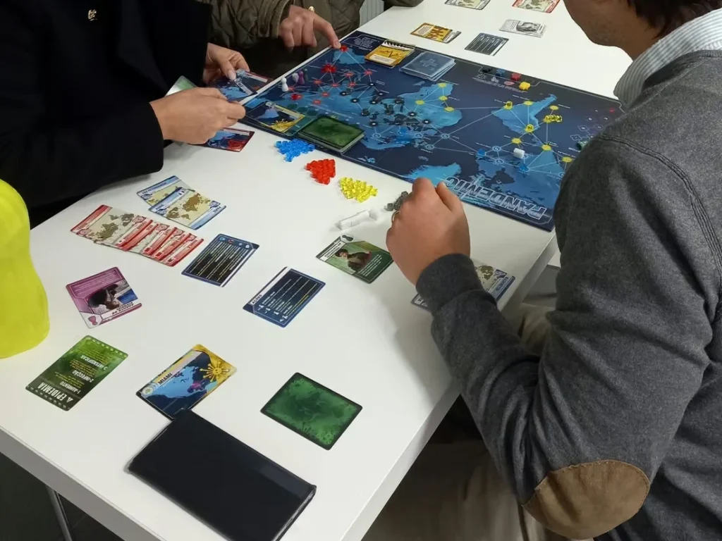 Equipa a jogar um jogo de tabuleiro cooperativo numa sala de reuniões