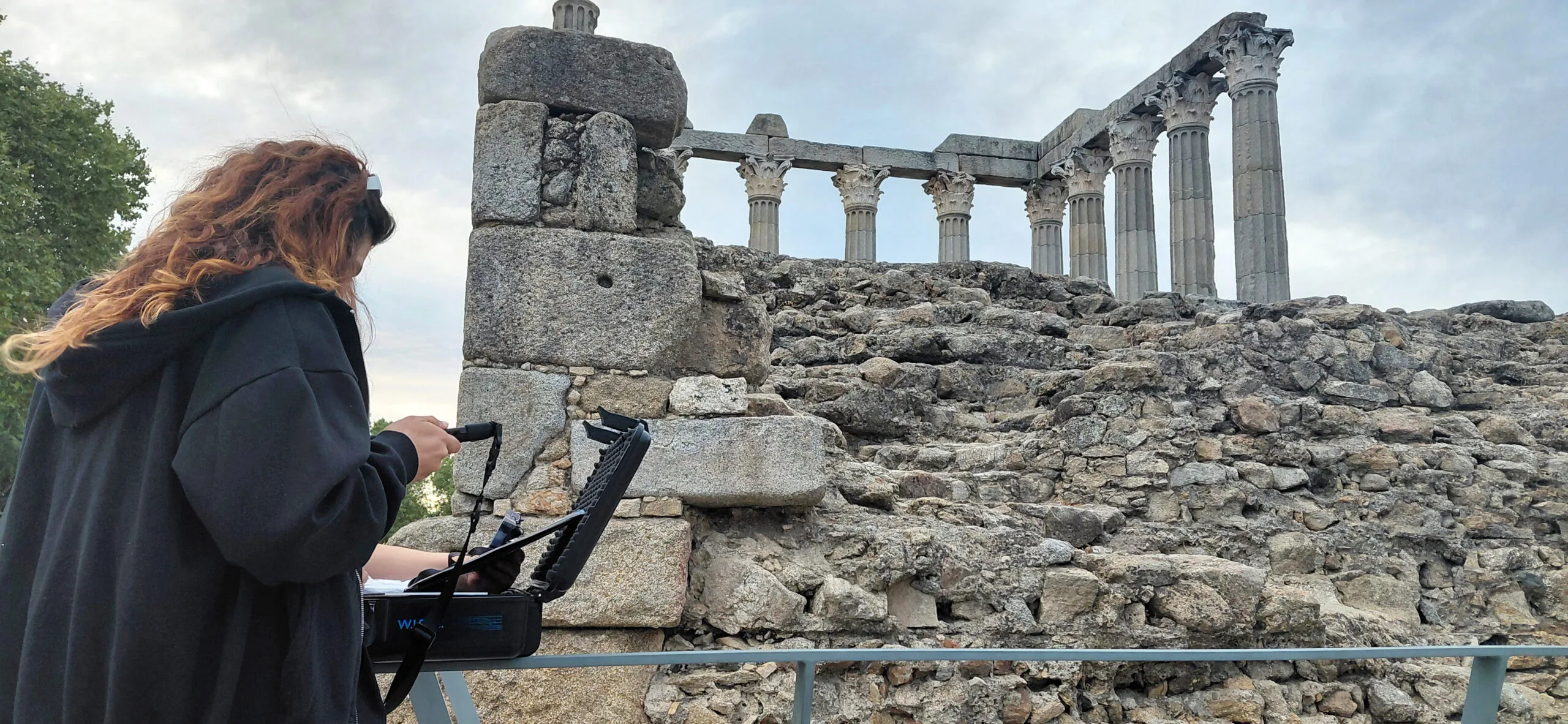 Participante com o iPad do escape game junto ao Templo Romano de Évora